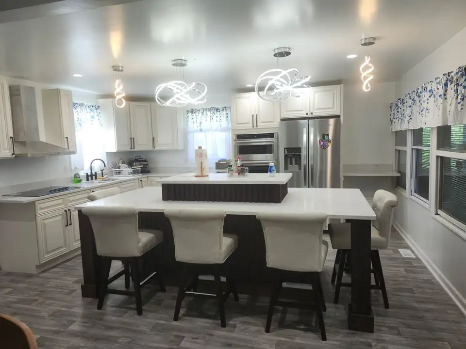 Cabinets and countertops in Rockingham, NC: large kitchen with white raised-panel cabinets, a two-level white quartz island with seating and modern pendant lights