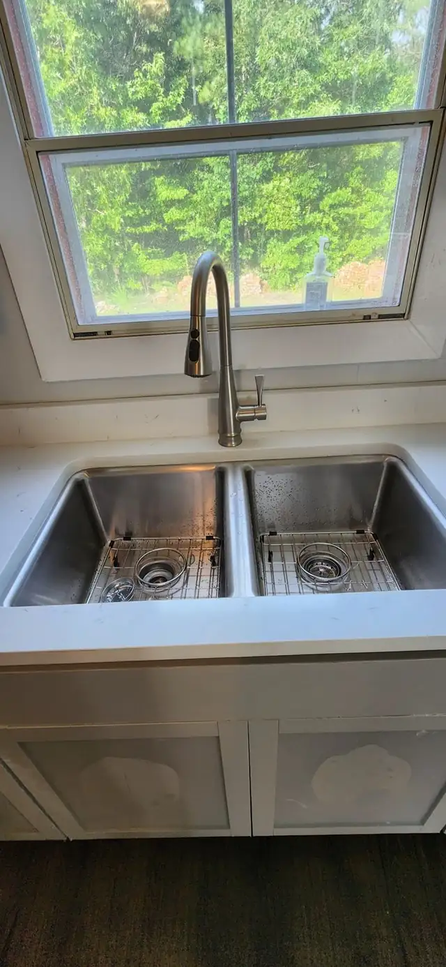 Stainless double-bowl undermount sink with grids in a white countertop